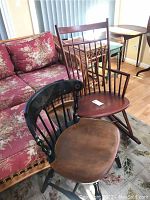 Side view of both chairs next to floral couch, showing overall shape and materials