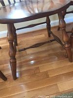 Close-up of turned wooden legs and stretcher of Windsor chair showing condition and craftsmanship.