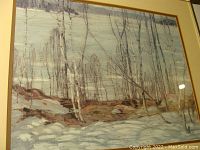 Framed print of a wintery lakeside forest scene with birch trees, snow, and rocks. Image taken front on showing print and frame.