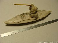 Front view of the Capilano Inuit kayaking sculpture with ruler for scale.
