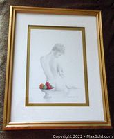 Image of the framed artwork showing a nude woman in pencil with a bowl of fruit in color, signed by the artist.