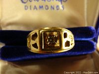 Front view in box showing square-set round diamond and heart-shaped cutouts.
