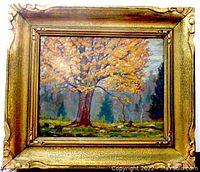 Frontal image showing the framed oil painting of an autumn tree with vibrant foliage in a detailed gold frame.
