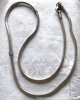 Full view of the sterling silver Pandora snake chain necklace laid out on a cloth surface showing its length and chain style.
