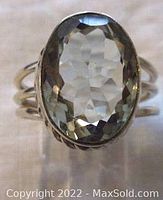 Front view of the ring showing the large faceted oval green amethyst set in a bezel with twisted rope detail.