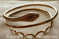 Angled photo showing overall coiled snake design and detailed head with red stones.