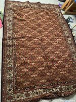 Full view of large vintage area rug showing overall floral pattern and border
