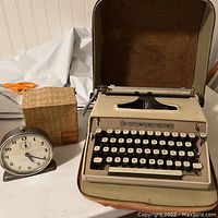 Singer Graduate typewriter in beige leather hard case next to Westclox Bingo alarm clock and original box