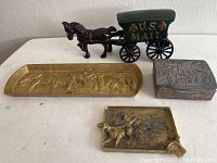 US Mail horse and carriage toy, brass tray, Asian cedar box, and dog ashtray arranged on table