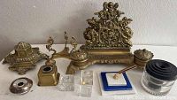 Full view of all vintage desktop ink wells and pen stands arranged on table.