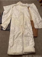 Photo showing long cream-colored vintage kimono with sleeve details and embroidery.