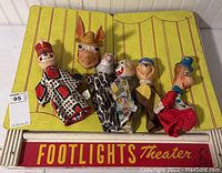 Full view of wooden Footlights puppet theater frame with 5 puppets arranged on it.