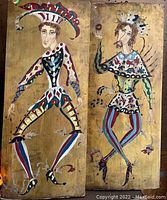 Two wooden panels with colorful jester paintings side by side, showing detail in costumes and pose.