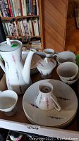 Overview of all 21 pieces: coffee pot, creamer, sugar bowl, cups, saucers, plates