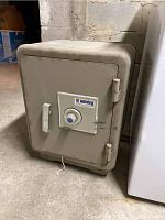 Full view of gray Sentry safe placed on basement floor against wall