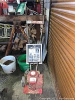 Front view of red Mantis tiller with attached manual holder