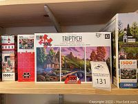 Shelf with multiple boxed jigsaw puzzles, showing a 3x500 piece Triptych set, 1500 pieces total, and other 1000 piece puzzles.