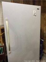 Exterior view of the Kenmore freezer showing white door with vertical handle and soiled surface.