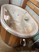 Exterior wood-paneled side view of Marquis spa with attached pump