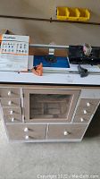 Top view of router table with phenolic insert, fence, jigs, and accessories on table surface
