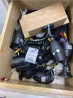 Drawer containing multiple Qsee bullet cameras with mounting brackets and attached cables