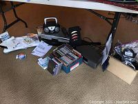Overall view of lot including VHS/DVD players, audio system, portable DVD player, Wii equipment, CDs, and cables
