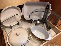 Photo of various baking dishes and bowls including Pyrex glass bowls, Corning Ware quiche dish, and Lenox casserole dish with lid.