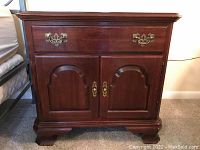 Front view of Ethan Allen wood nightstand showing drawer and lower cabinet doors with brass hardware.