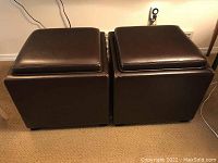Two brown leather storage cubes side by side on carpeted floor, showing front and top sides.
