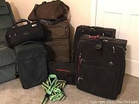 Full view of all luggage and bags included in the lot, showing various sizes and brands.