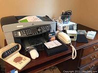 HP Officejet 7310 printer and miscellaneous electronics including phone, speakers, cables, and copy paper