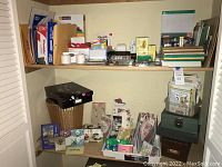Shelf with greeting cards, storage box, waste basket, and various stationery items