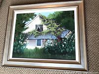Full frontal view of framed painting showing cottage scene and frame style