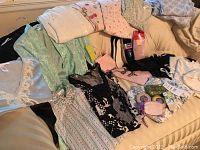Overall lot of sleepwear, socks, soaps, and lingerie items spread on a surface showing variety and tags.