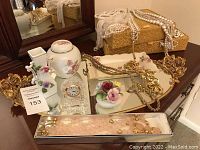 Photo showing glass and brass mirror tray with jewelry and decorative jars arranged on it