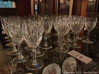 Group of clear cut crystal wine glasses arranged in two rows showing multiple pieces