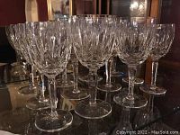 Twelve Waterford crystal stemware glasses arranged in rows on mirrored surface