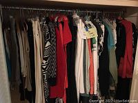 Full closet view of hanging garments, mixed colors and patterns