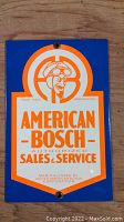 Photo of rectangular enamel American Bosch sign with vintage logo and text from United American Bosch Corporation.
