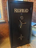 Front view of black RedHead safe showing logo, keypad and three-spoke handle