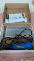 Rotary tool, plastic organizer with accessories, and instruction manual in opened original box.
