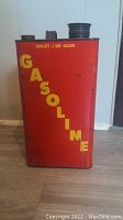 Front view showing red can with yellow 'GASOLINE' lettering and capacity statement.