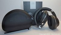 Vankyo C751 wireless headset shown unfolded alongside its semi-rigid black textured carrying case and product box