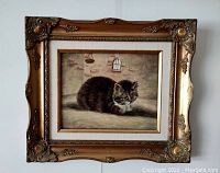 Frontal view of framed oil painting showing cat against brick wall background