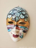 Mask with gold band eye covering and button-patterned hair with floral detail
