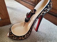 Leopard print high heel shoe art piece with matching high heel wine stopper inserted inside.