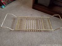 Front view showing the bath shelf in a compressed form on carpet