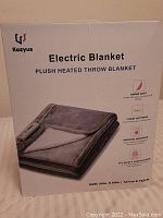 Box front showing Kozyus Electric Blanket plush heated throw in grey color, 50x60 inches, featuring 3 heat settings and safety certification.
