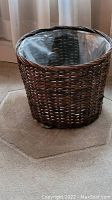 Full view of round wicker basket with plastic liner inside, placed on a carpeted floor