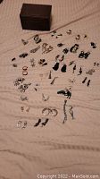 Overview of multiple pairs of earrings and a jewelry box scattered on a surface